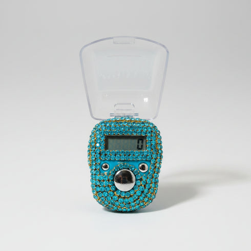 Blue rhinestone-encrusted digital clock on a wooden surface