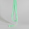 A hand holding a bundle of light green beaded strands, likely beads for jewelry making, against a busy background of other colorful beads and craft supplies.