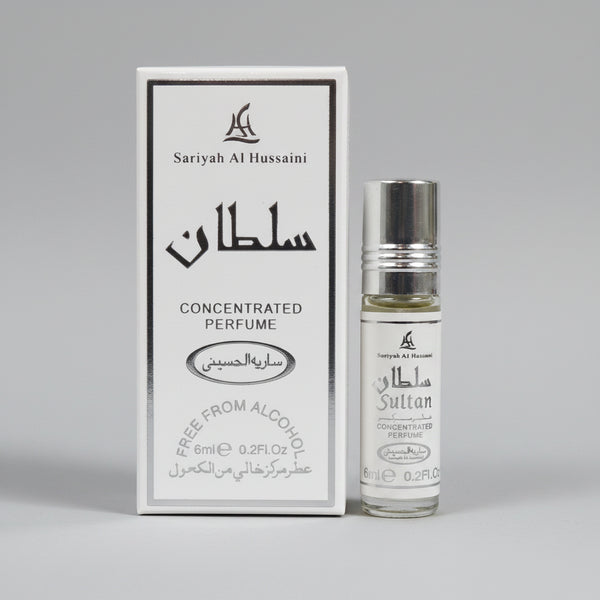 A small clear perfume roll-on bottle with a silver cap stands beside its white rectangular box on a wooden surface. The packaging and bottle are printed with the brand name 'Sattyah Al Hussaini' and Arabic text, including 'CONCENTRATED PERFUME' and 'FREE FROM ALCOHOL'.