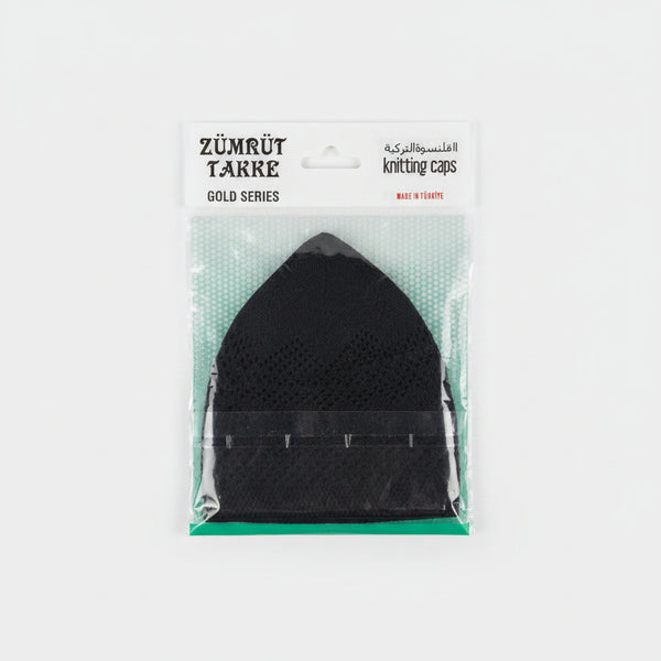 A packaged black mesh knitting cap from the Zürürüt Takre Gold Series, sealed in clear plastic with a white paper header card, resting on a speckled countertop.