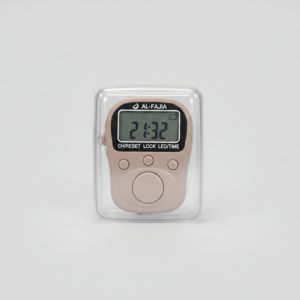 A small digital lock timer with a gray LCD screen and round buttons, shown inside a clear plastic protective case and held by a hand. The background is a blurry indoor desk environment.