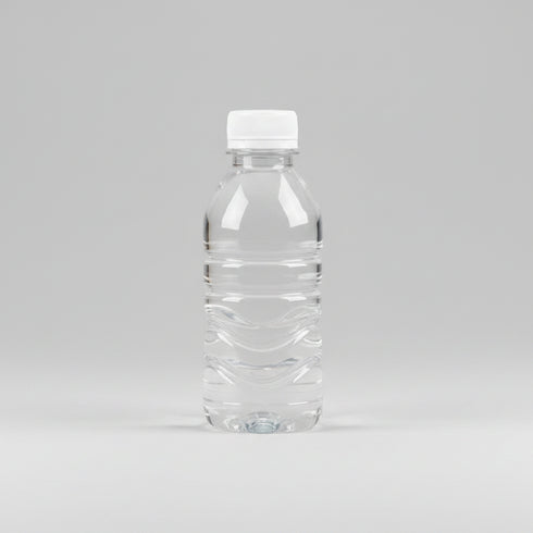 Hand holding a clear bottle with a white cap against a neutral background