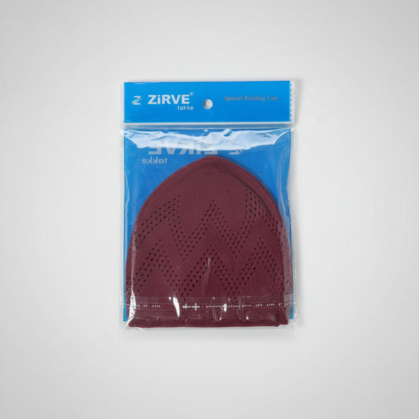 A packaged maroon knit face covering or mask by ZIRVE, sealed in clear plastic with a blue backing card, photographed on a tiled floor.